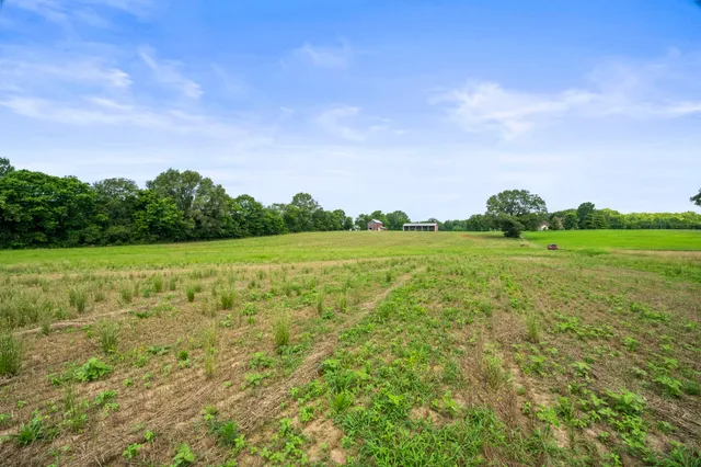 a view of a green field with wooden fence