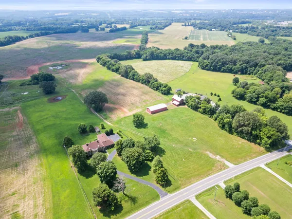 an aerial view of lake residential house with swimming pool and green space