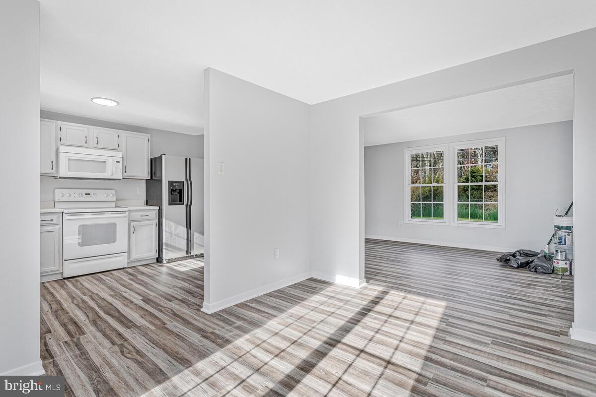 123 Cove Point Road Lusby, MD 20657 - Photo 12 of 38 a view of a kitchen with wooden floor and a refrigerator