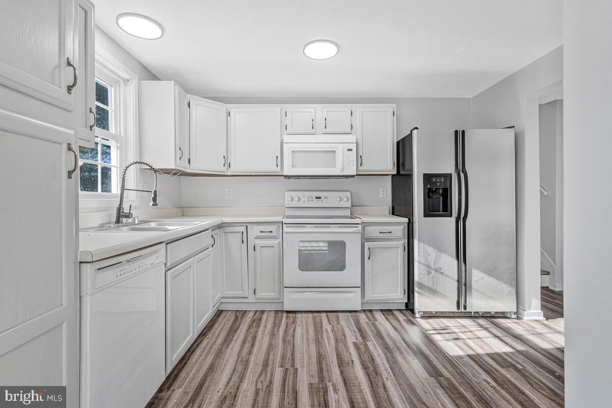 123 Cove Point Road Lusby, MD 20657 - Photo 13 of 38 a kitchen with white cabinets and white appliances