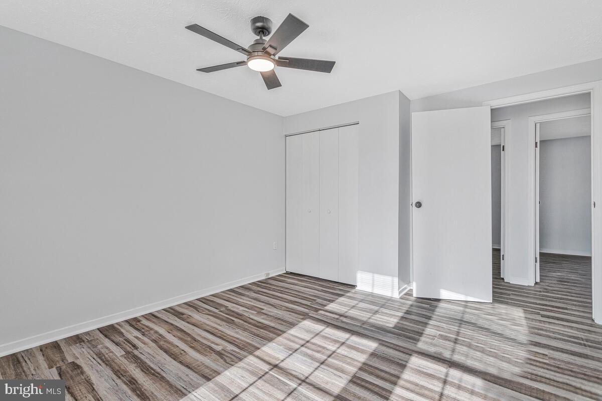 123 Cove Point Road Lusby, MD 20657 - Photo 19 of 38 a view of a big room with wooden floor and a ceiling fan