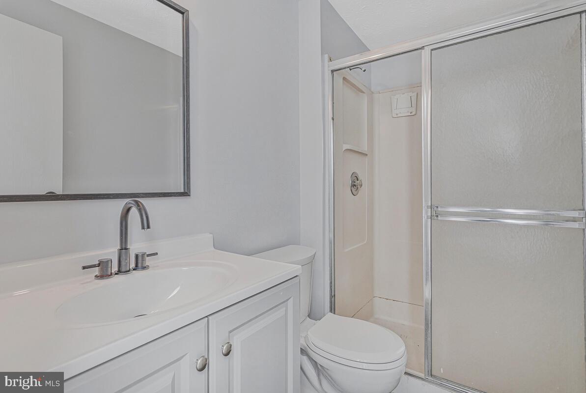 123 Cove Point Road Lusby, MD 20657 - Photo 22 of 38 a bathroom with a sink a mirror a toilet and shower