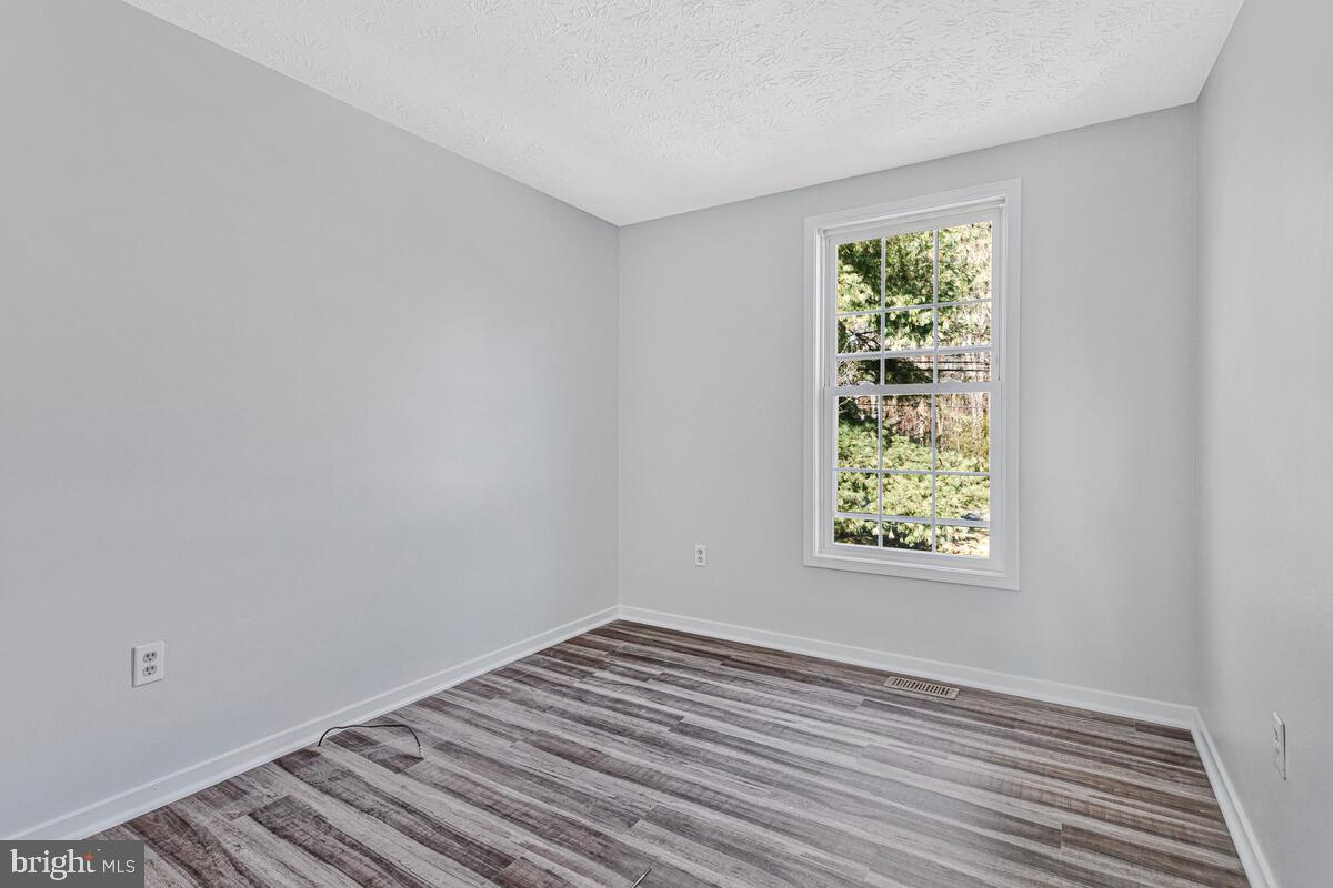 123 Cove Point Road Lusby, MD 20657 - Photo 26 of 38 an empty room with wooden floor and windows