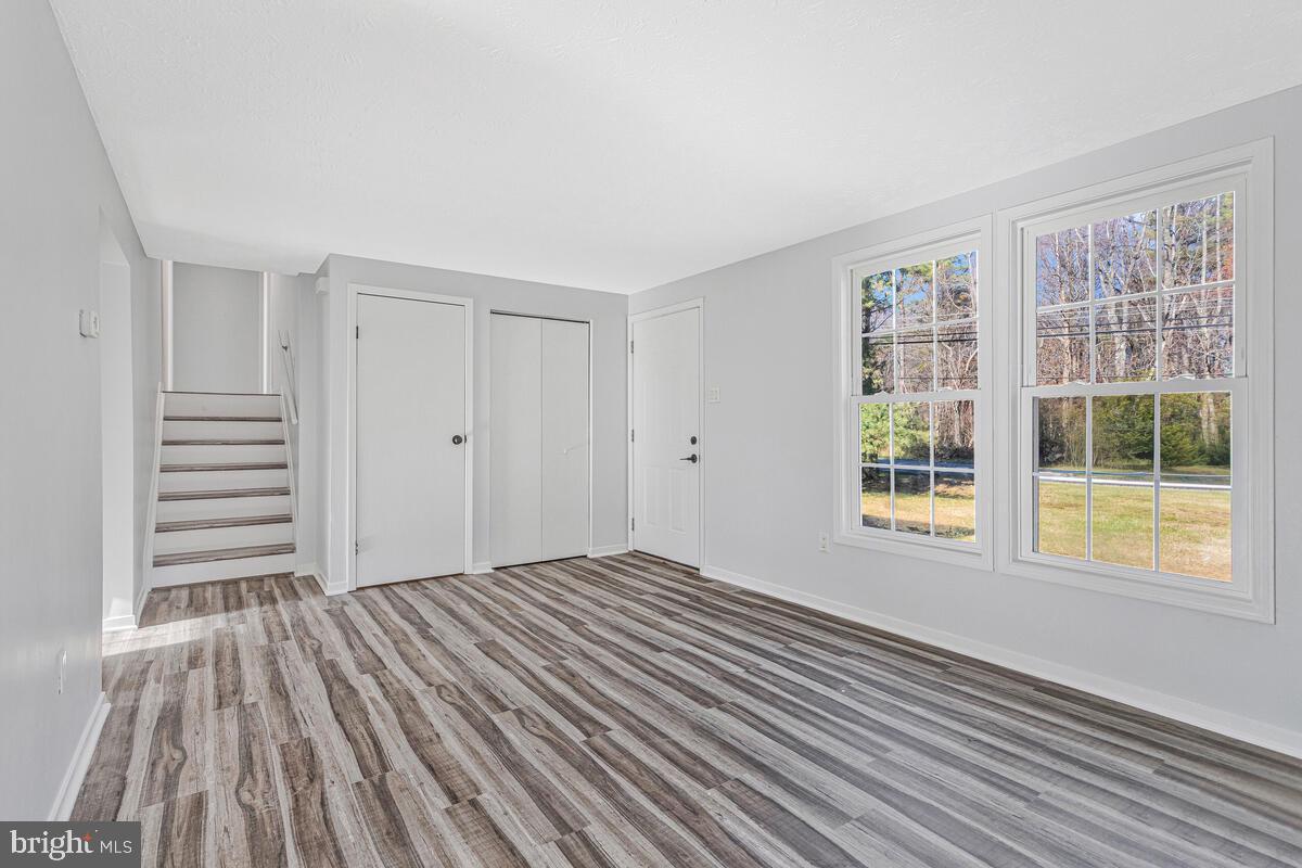 123 Cove Point Road Lusby, MD 20657 - Photo 9 of 38 a view of an empty room with wooden floor and a window