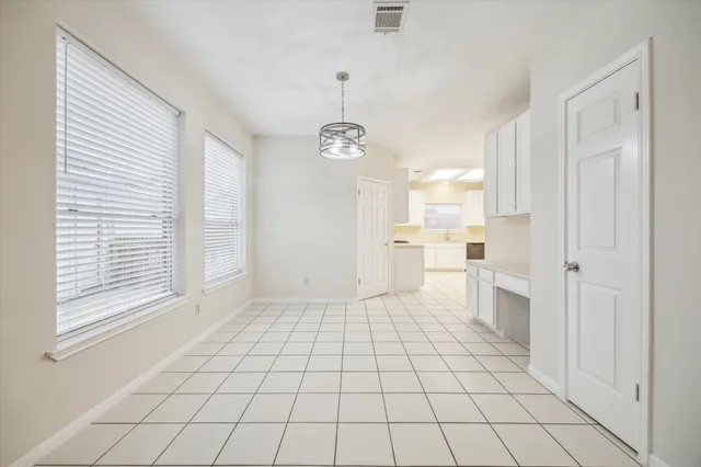 a view of a kitchen with a white cabinets and window