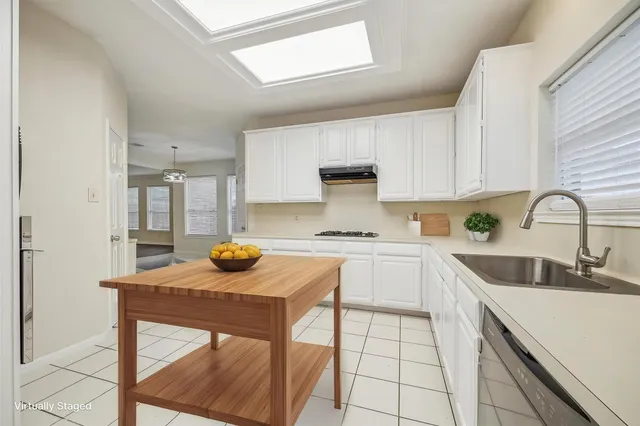 a kitchen with a sink a stove and cabinets