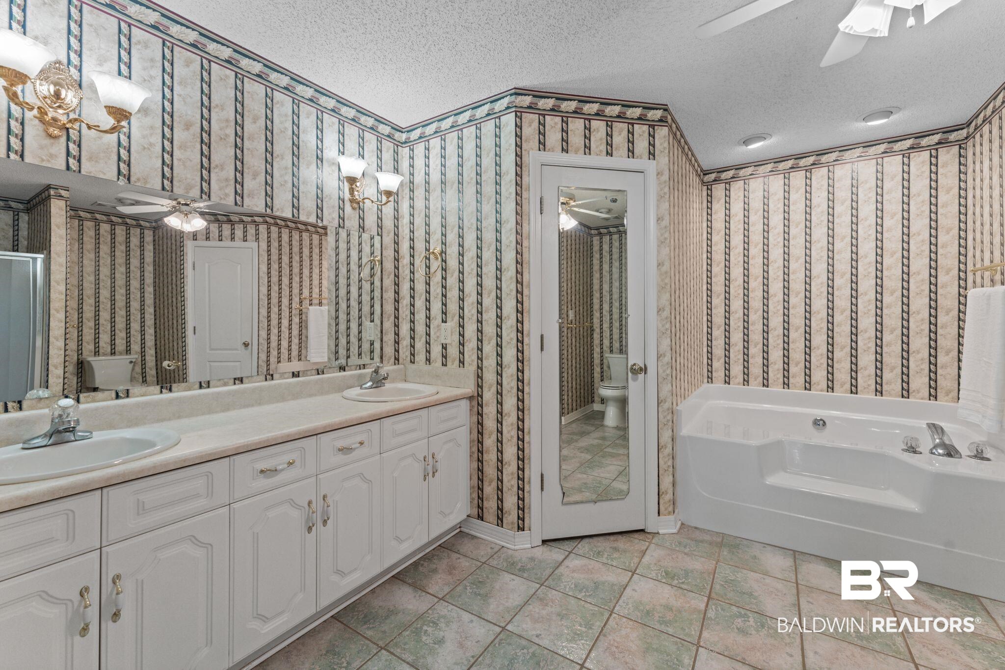 888 Mobile Cut-Off Road St. Stephens, AL 36569 - Photo 23 of 54 Full bath with ceiling fan, double vanity, a garden tub, a textured ceiling, and light tile patterned floors