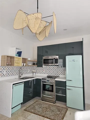 a kitchen with stainless steel appliances granite countertop a stove a refrigerator and a sink