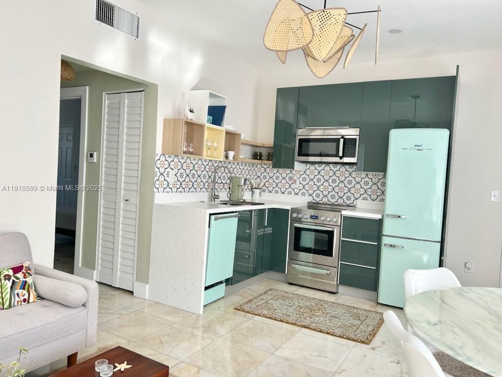 801 8th Street, Unit 201 Miami Beach, FL 33139 - Photo 13 of 37 a kitchen with stainless steel appliances kitchen island granite countertop a stove and a sink