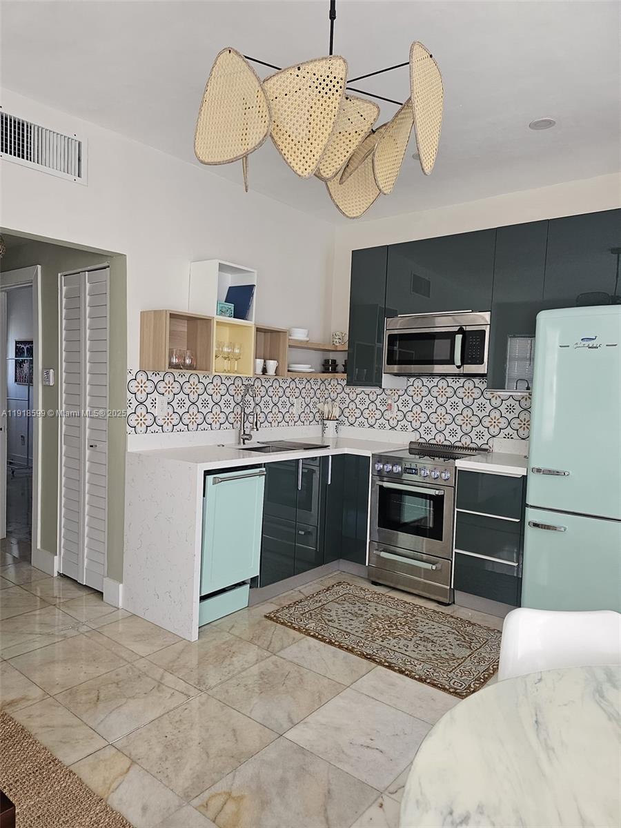 801 8th Street, Unit 201 Miami Beach, FL 33139 - Photo 14 of 37 a kitchen with a stove and a refrigerator