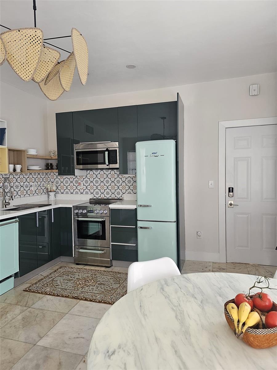 801 8th Street, Unit 201 Miami Beach, FL 33139 - Photo 15 of 37 a bedroom with a bed and a chandelier