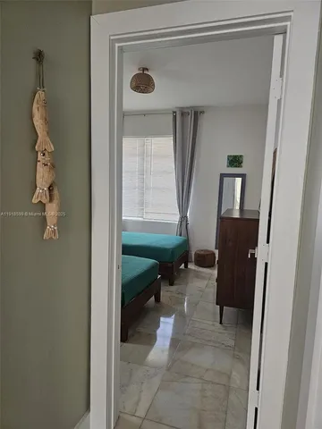 a view of a hallway to a livingroom and a window