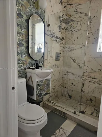 a bathroom with a sink a toilet and a mirror