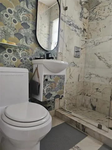 a bathroom with a toilet sink and mirror