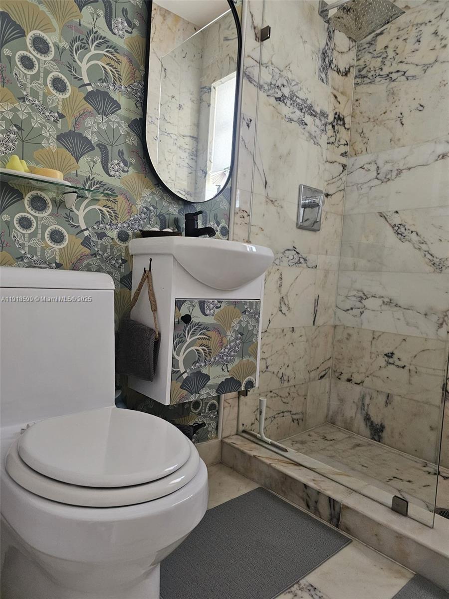 801 8th Street, Unit 201 Miami Beach, FL 33139 - Photo 26 of 37 a bathroom with a toilet sink and mirror