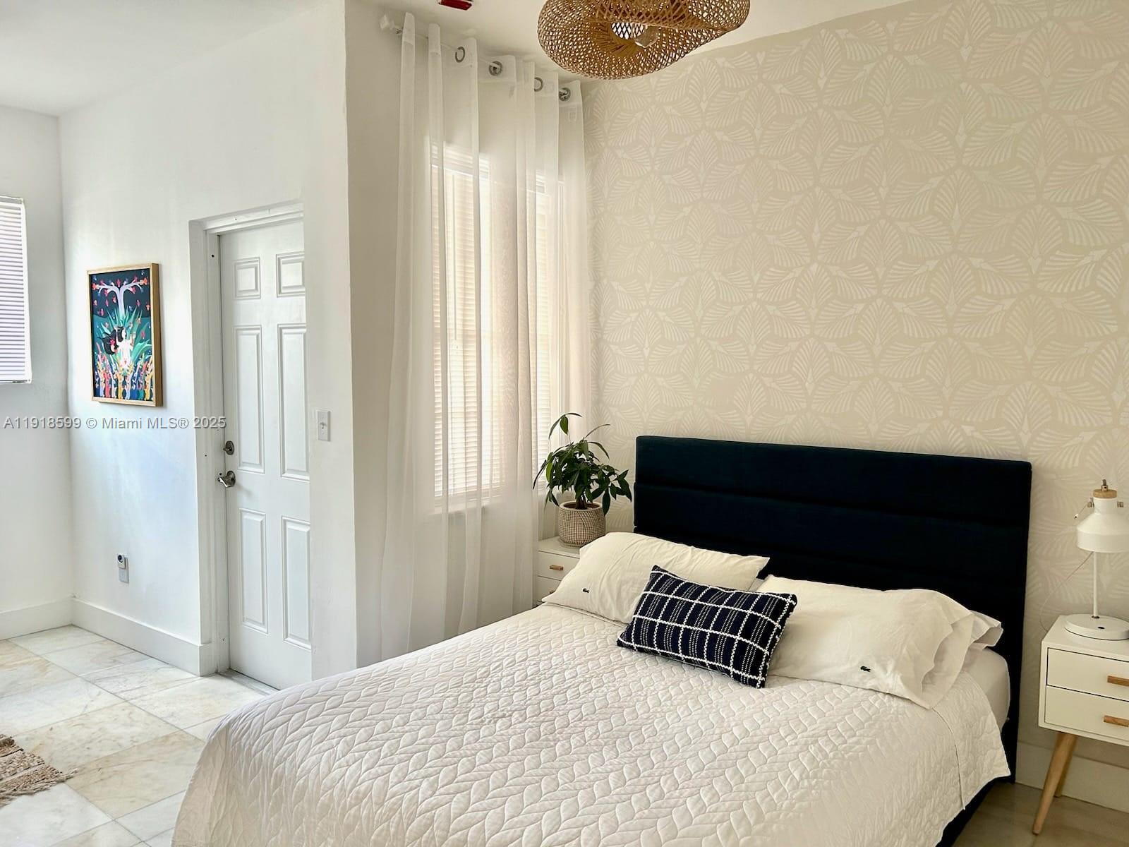 801 8th Street, Unit 201 Miami Beach, FL 33139 - Photo 29 of 37 a bedroom with a bed and wooden floor