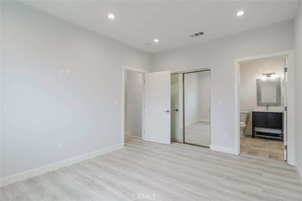9035 Rathburn Avenue, Unit 1/2 Northridge, CA 91325 - Photo 12 of 25 a view of an empty room with wooden floor and a ceiling fan