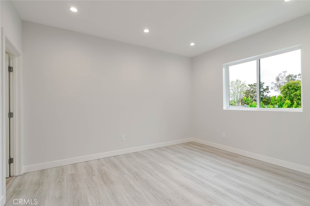 9035 Rathburn Avenue, Unit 1/2 Northridge, CA 91325 - Photo 13 of 25 an empty room with wooden floor and windows