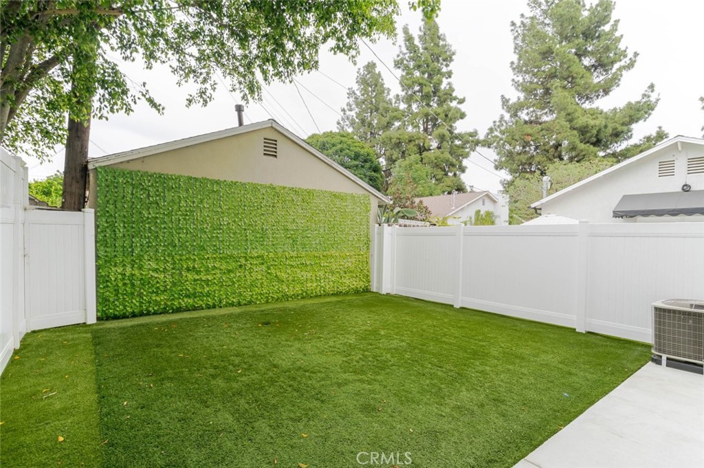 9035 Rathburn Avenue, Unit 1/2 Northridge, CA 91325 - Photo 22 of 25 a backyard of a house with plants and large trees