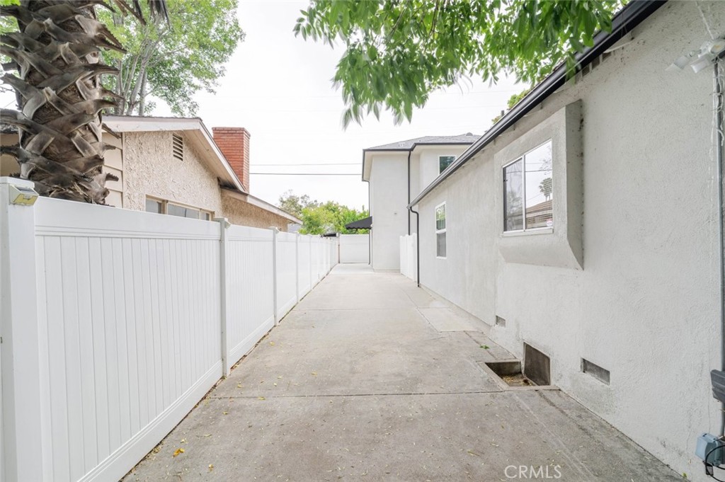 9035 Rathburn Avenue, Unit 1/2 Northridge, CA 91325 - Photo 23 of 25 a view of a white house with a large tree and wooden fence