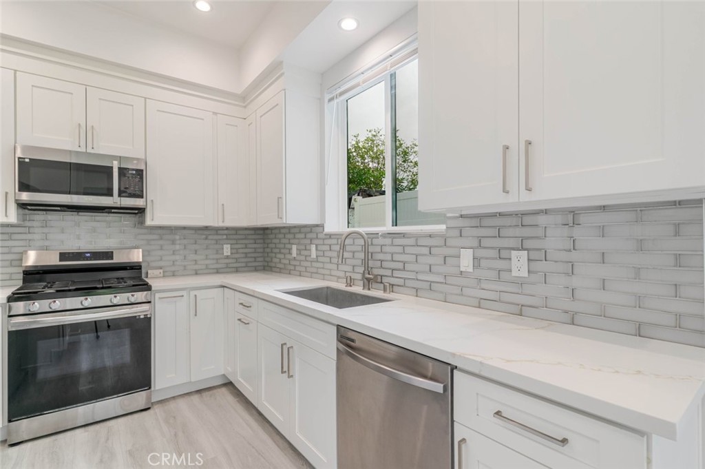 9035 Rathburn Avenue, Unit 1/2 Northridge, CA 91325 - Photo 8 of 25 a kitchen with a sink stove and microwave