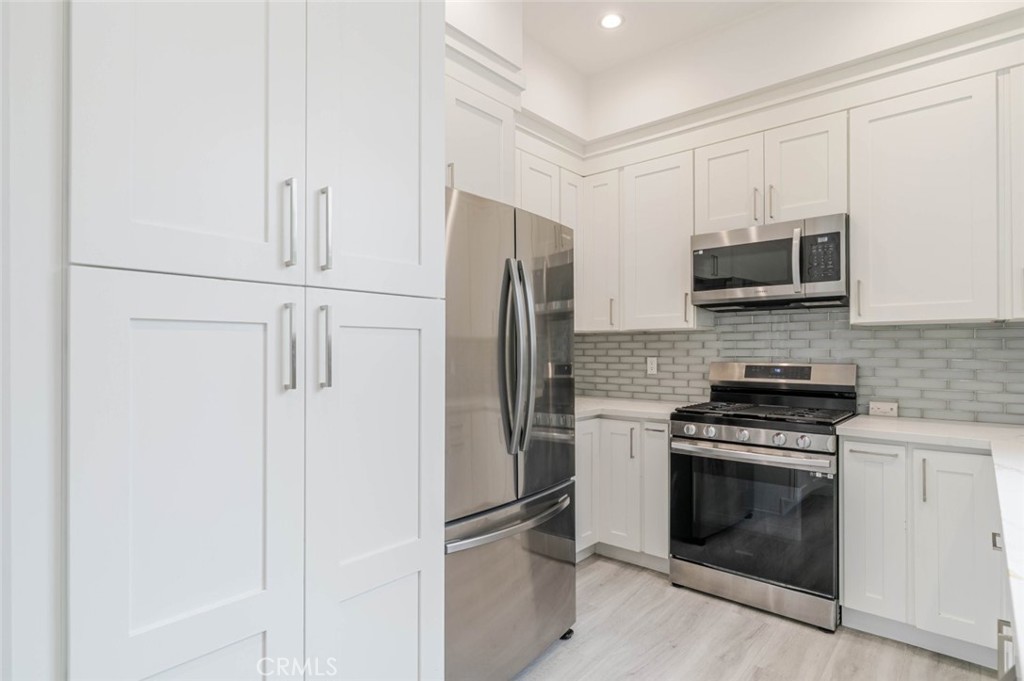 9035 Rathburn Avenue, Unit 1/2 Northridge, CA 91325 - Photo 9 of 25 a kitchen with stainless steel appliances granite countertop white cabinets and a refrigerator