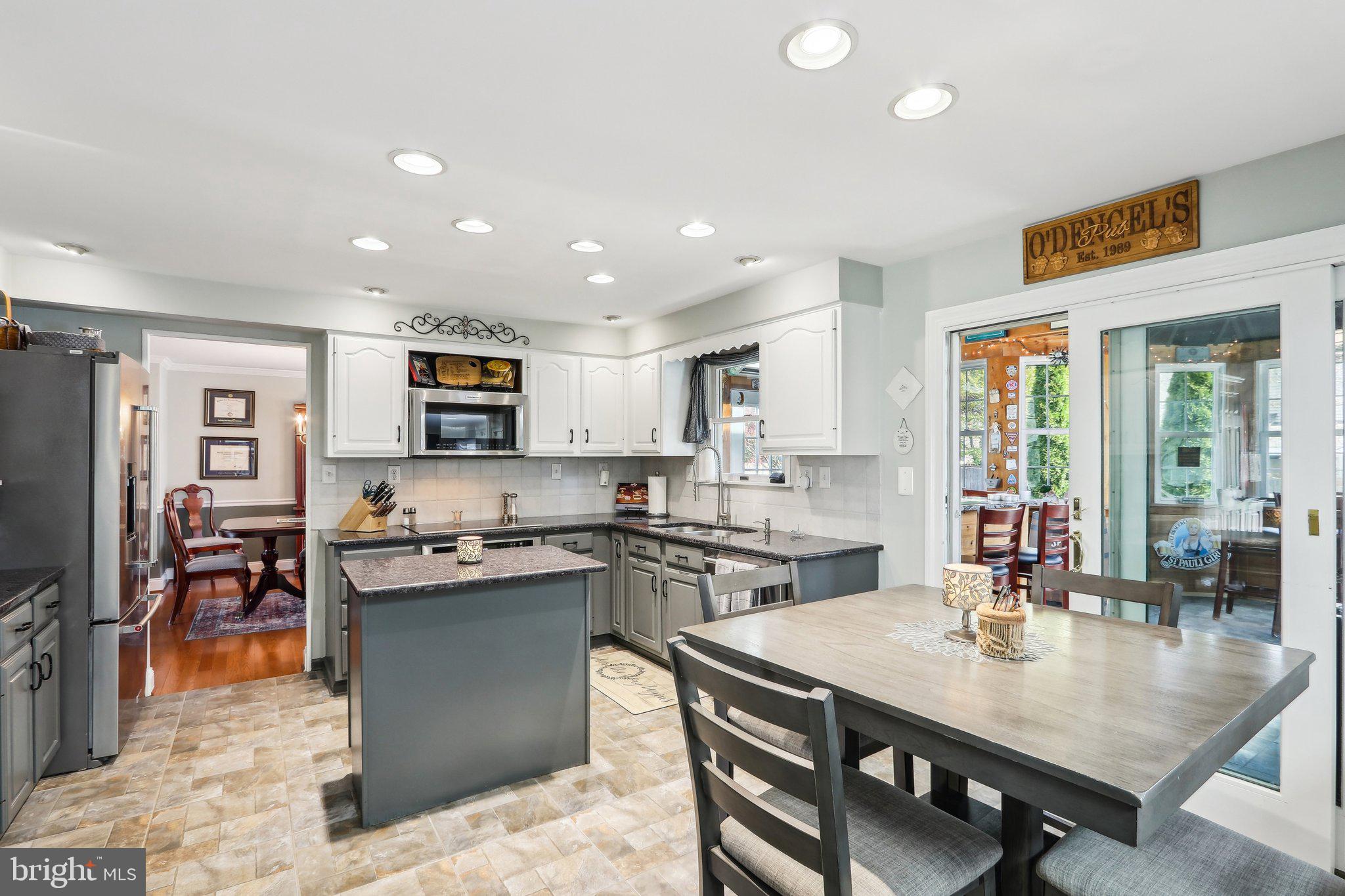 23 Yale Road Marlton, NJ 08053 - Photo 11 of 42 a kitchen with stainless steel appliances granite countertop a stove top oven a sink a dining table and chairs with wooden floor