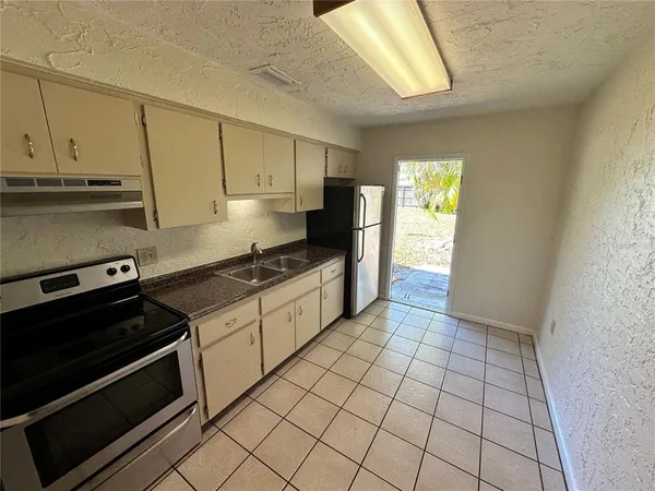 a kitchen with a stove a sink and a refrigerator