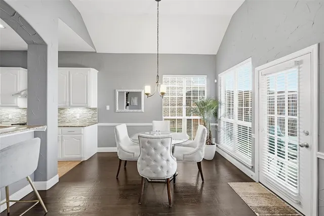 a dining room with furniture a chandelier and wooden floor