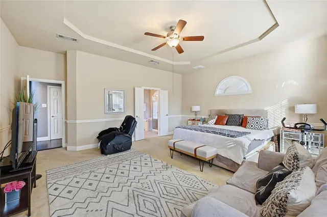 a bedroom with a bed a couch and a chandelier