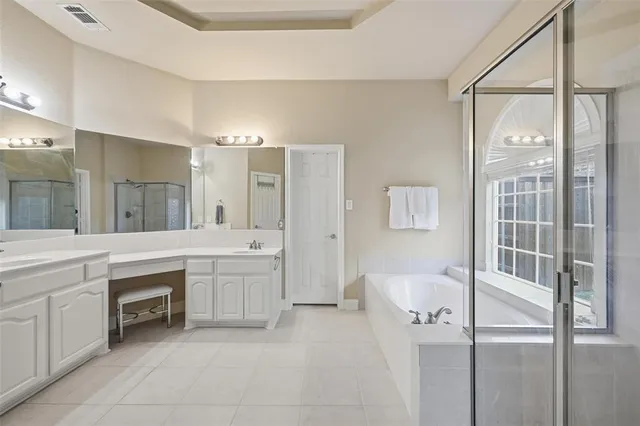 a spacious bathroom with a shower a sink and a mirror