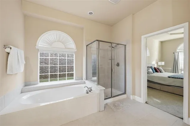 a view of spacious bedroom with a tub and large window