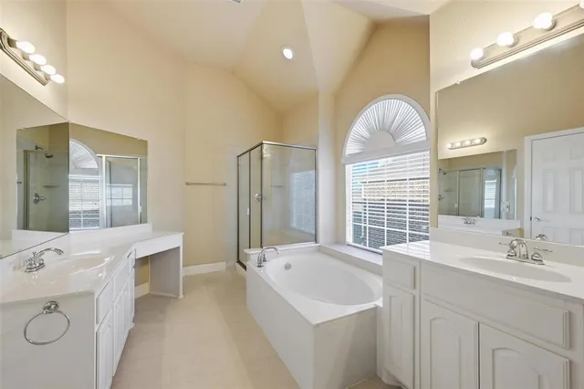a bathroom with a sink double vanity granite tub shower and a mirror