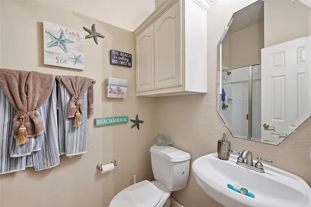 a bathroom with a sink toilet and a mirror