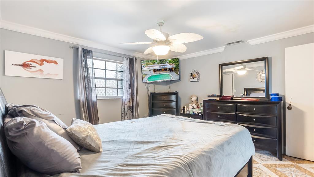 6624 Northwest 1st Court Margate, FL 33063 - Photo 17 of 17 a bedroom with a bed and a chandelier