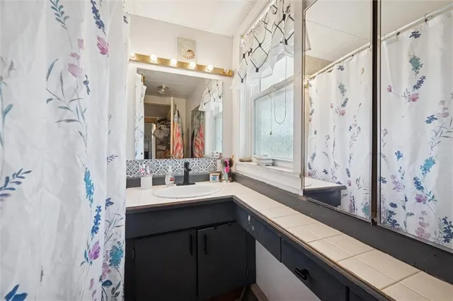 a bathroom with a double vanity sink mirror and shower