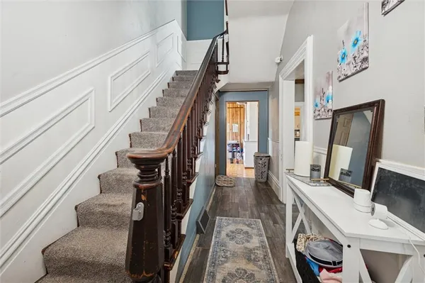 a view of hallway with stairs and wooden floor