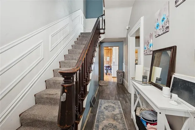 a view of hallway with stairs and wooden floor