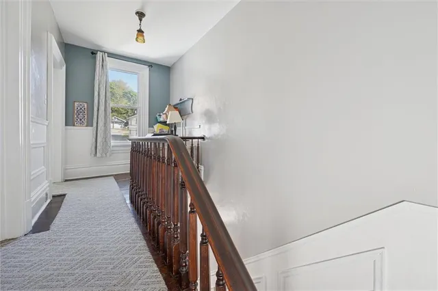 a view of a hallway with wooden floor and staircase