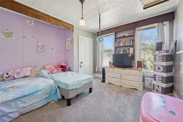 a bedroom with a bed dresser and a window