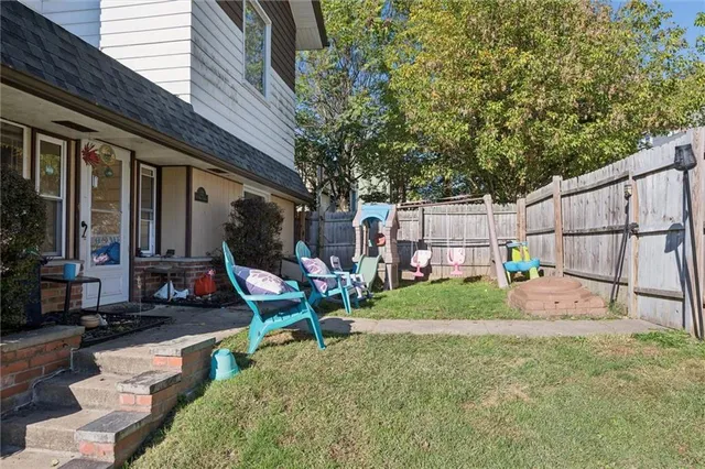 a view of backyard with seating space and wooden fence