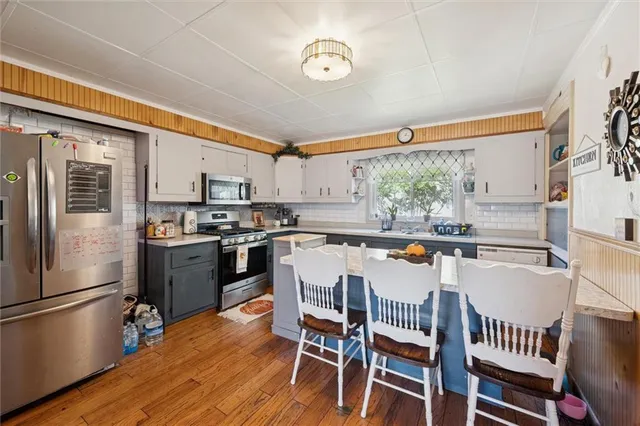 a kitchen with a table chairs refrigerator and microwave