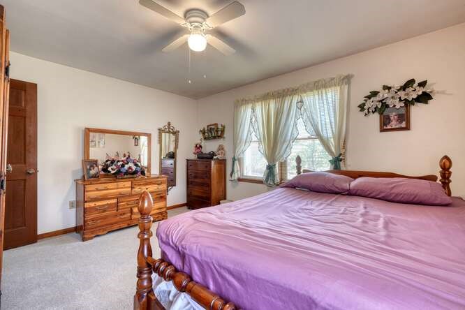 243 Allison Road Blairsville, GA 30512 - Photo 13 of 33 a bedroom with a large bed and a chandelier