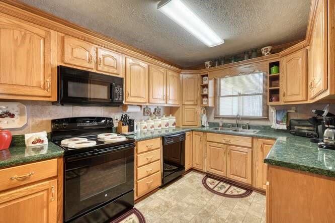 243 Allison Road Blairsville, GA 30512 - Photo 6 of 33 a kitchen with granite countertop a stove sink microwave and cabinets
