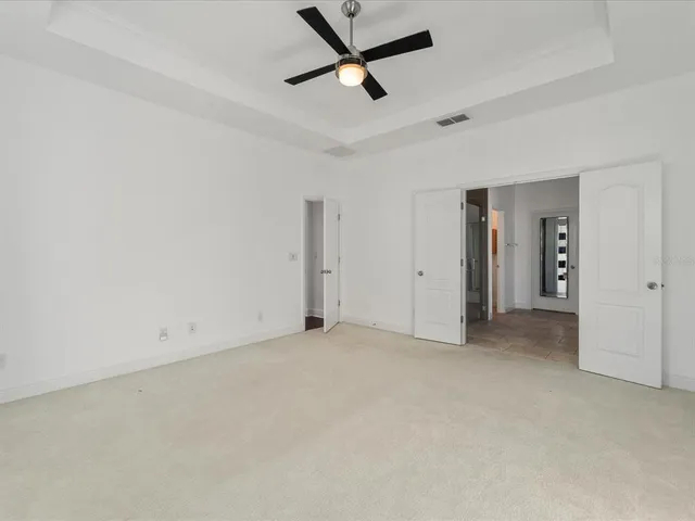 an empty room with closet and a ceiling fan
