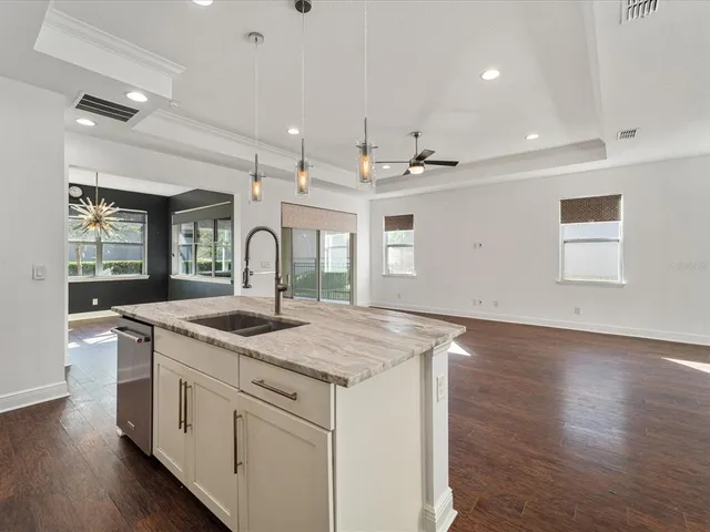 a kitchen with a sink stove and wooden floor