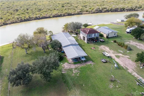 an aerial view of residential houses with outdoor space and lake view