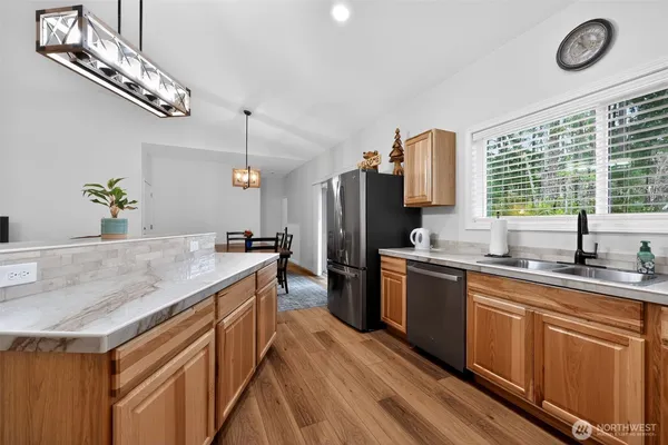 a kitchen with stainless steel appliances granite countertop a sink stove and refrigerator