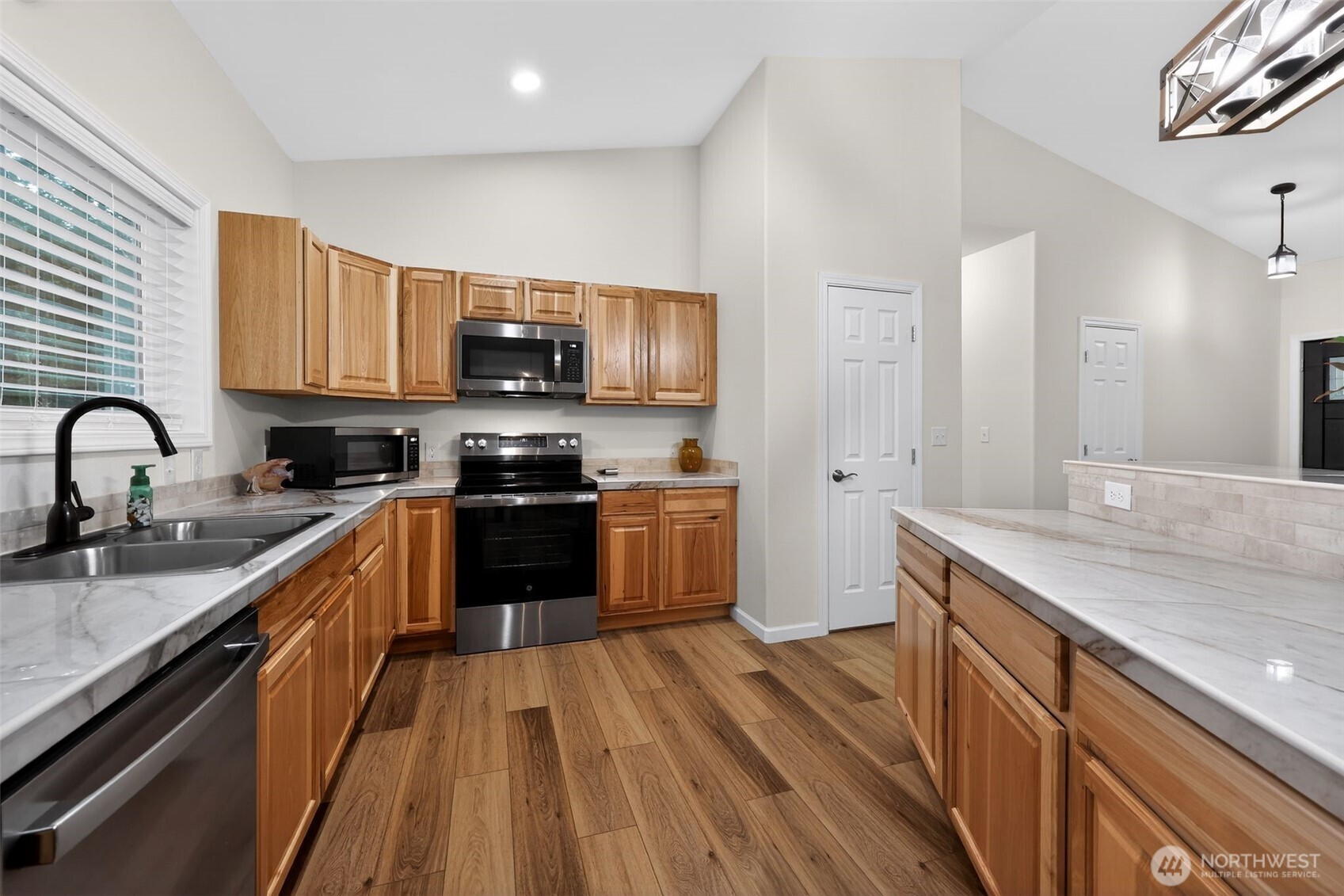 148 East Fox Run Lane Grapeview, WA 98546 - Photo 10 of 32 a kitchen with granite countertop a sink wooden floor and stainless steel appliances