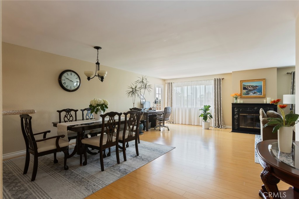 726 Elm Avenue, Unit 404 Long Beach, CA 90813 - Photo 4 of 31 a view of a dining room and livingroom with furniture wooden floor a rug and a clock